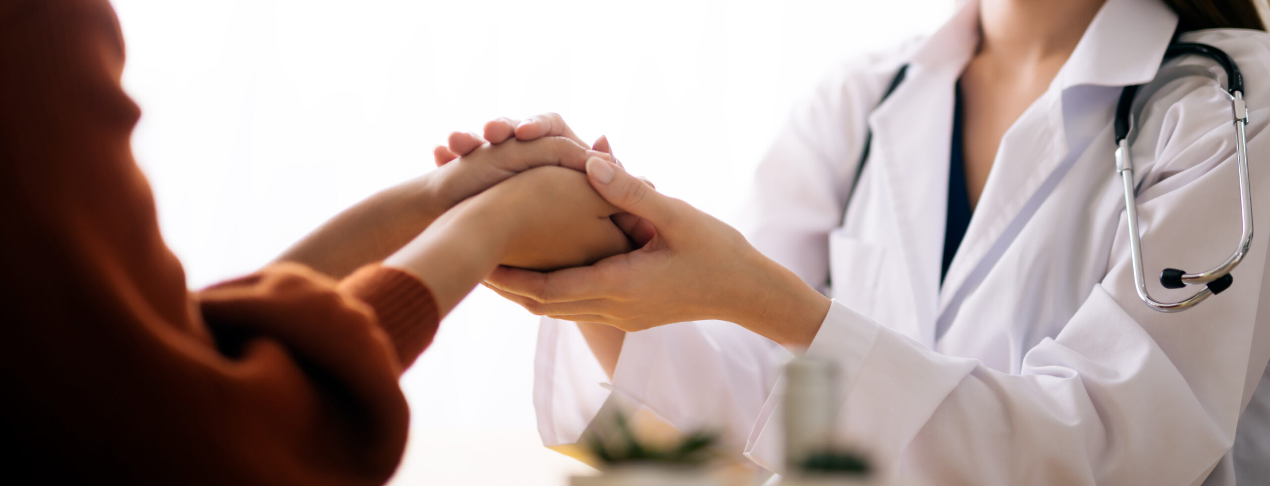 Doctor holding patients hand in an encouraging manner